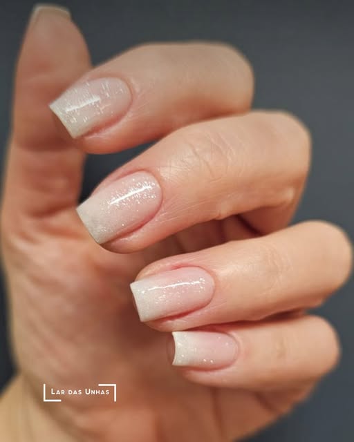 Unhas com esmaltação nude cintilante